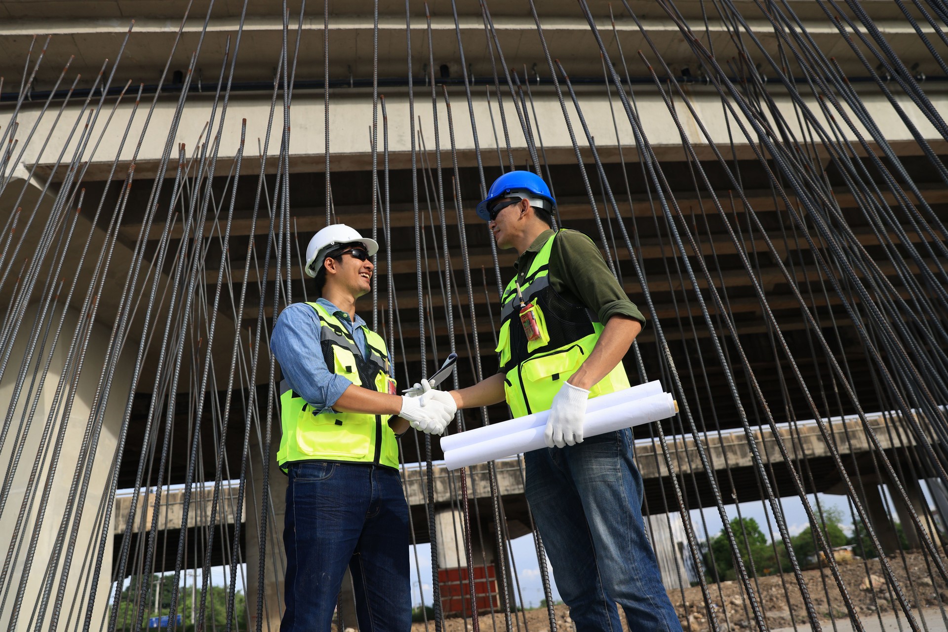 Pile Construction, Civil engineer handshake with project manager, Civil team working with blueprint  drawing at steel frame for pile construction site