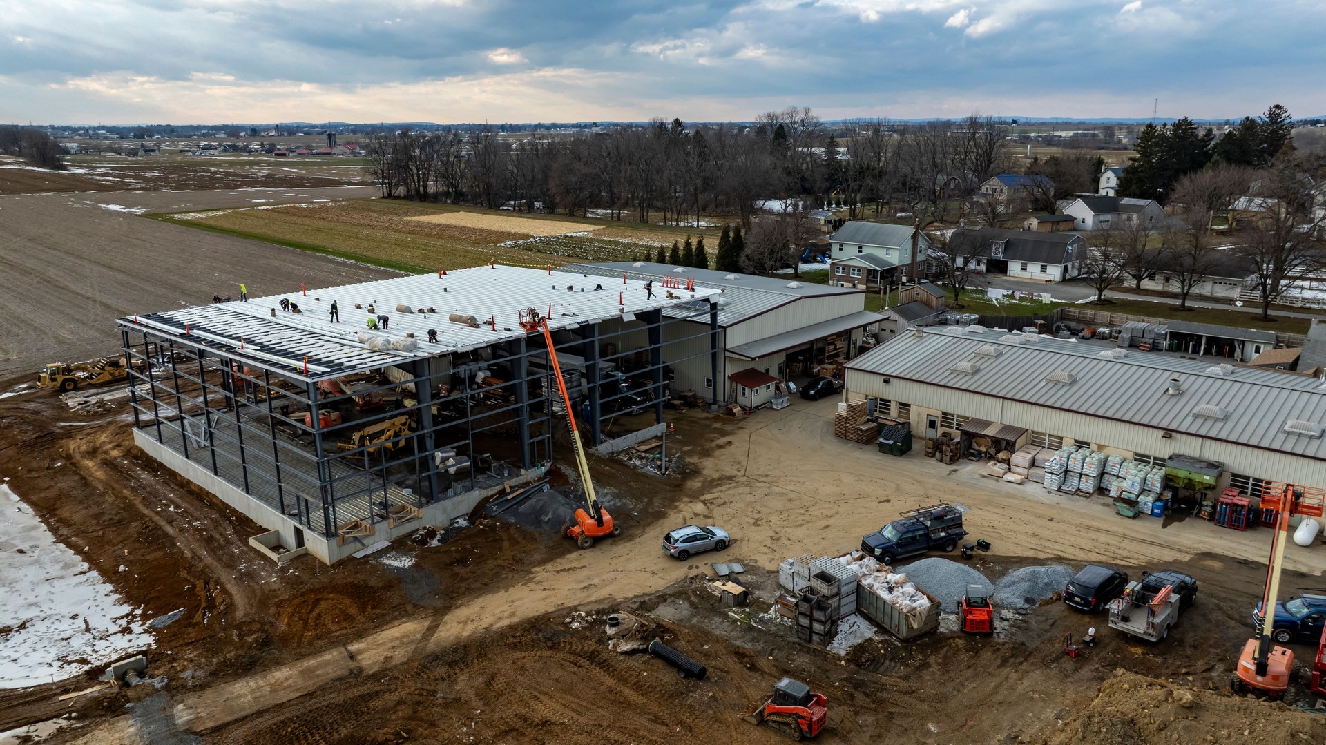 Construction of a Modern Facility in Rural Area Showing Progress With Machinery and Workers Engaged in Building Activities